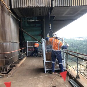 man securing crane cage chains on worksite