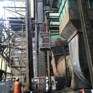 man standing near crane cage on worksite