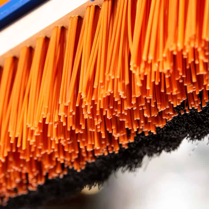 close up of orange broom bristles