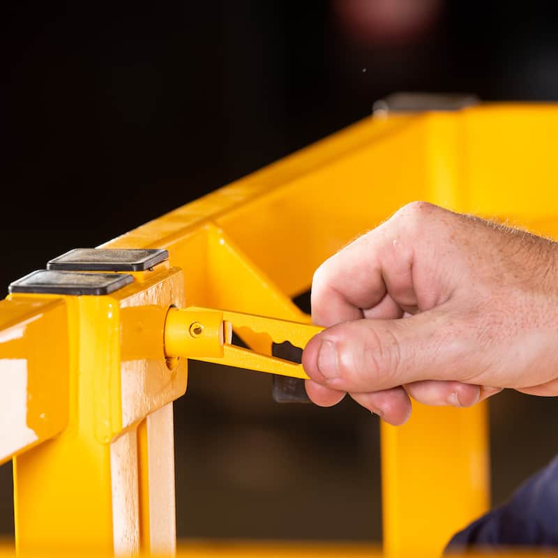 close up of someone opening the lock on a forklift safety cage