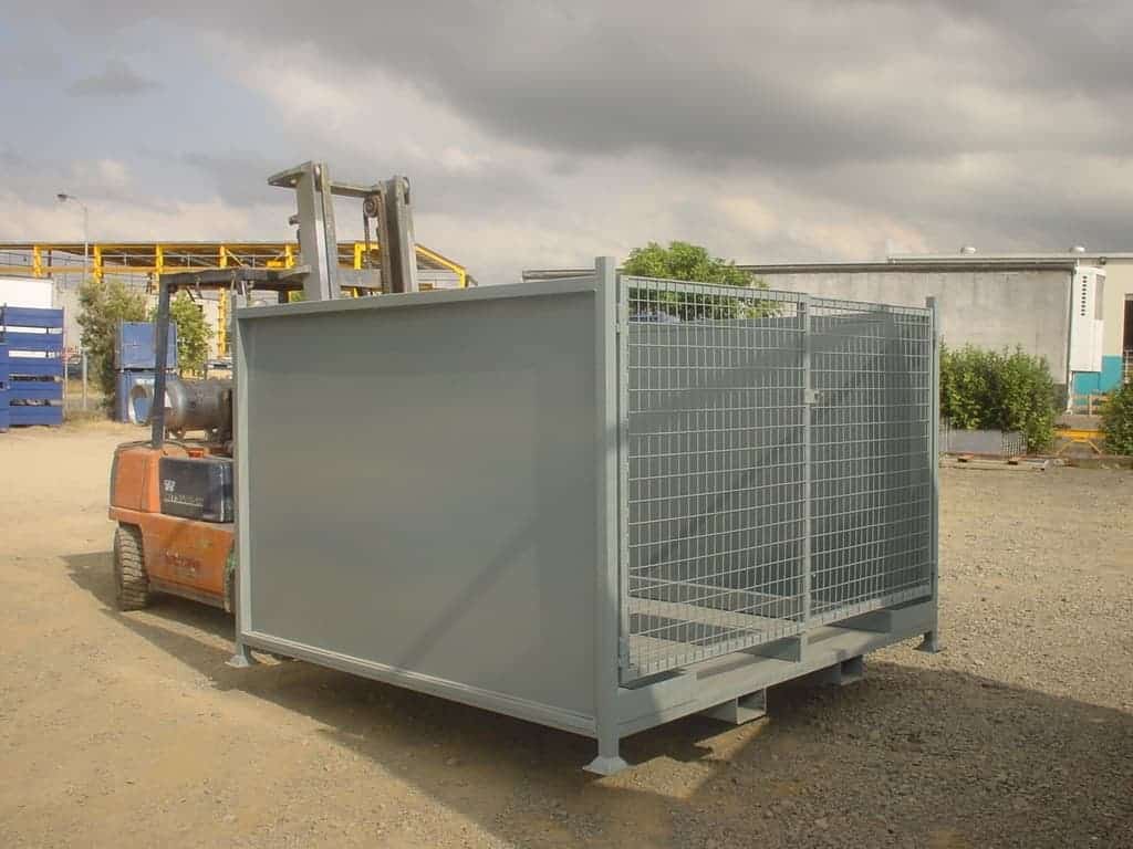 grey steel cage being transported by a forklift