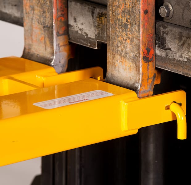 close up of a yellow forklift attachment, where it connects to the forklift