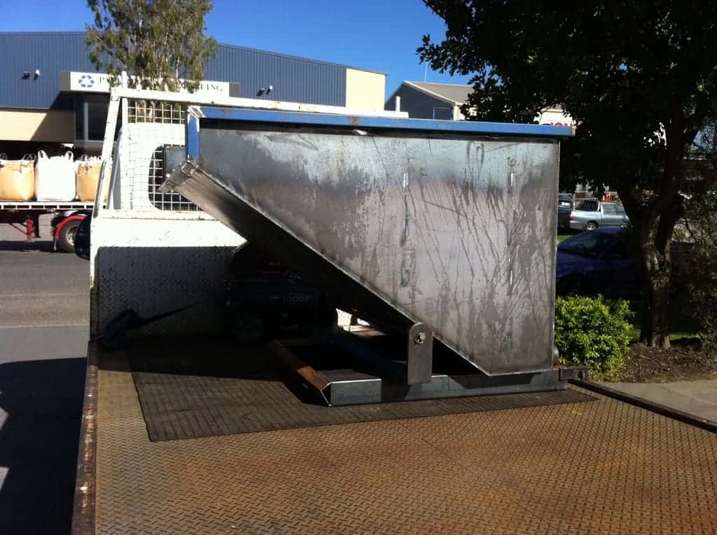 Steel Bin Tipper Attachment Resting on the Back of a Delivery Truck